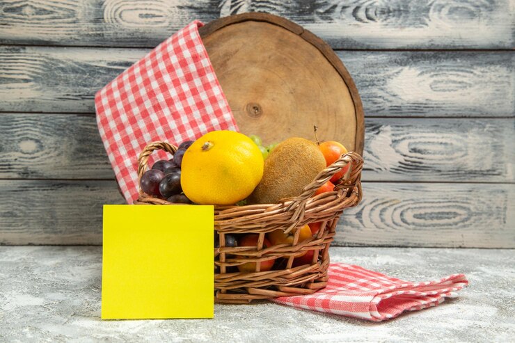 Foto grátis frutas frescas de vista frontal dentro da cesta no fundo cinza do caderno de frutas cítricas