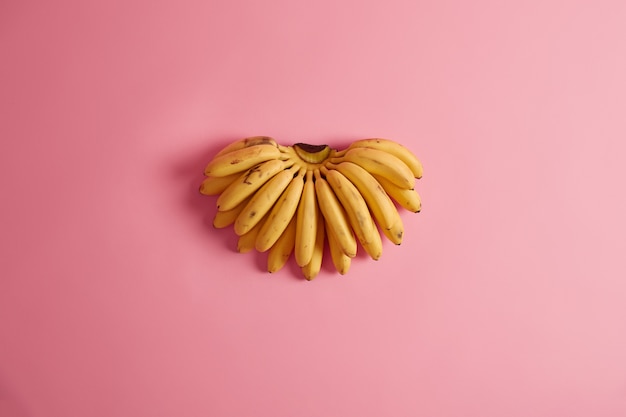 Foto grátis frutas mais comumente consumidas. cacho de bananas amarelas contendo grande variedade de potássio, vitaminas, minerais e antioxidantes, podem fazer parte do seu estilo de vida saudável. colheita alimentar importante.