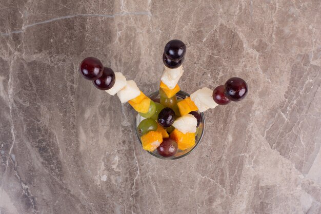 Frutas mistas varas em vidro na mesa de mármore.