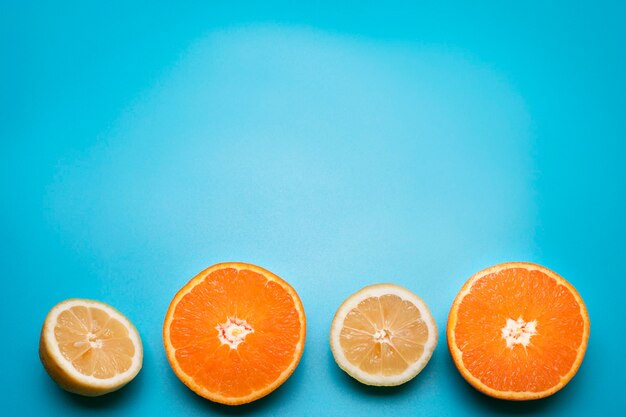 Frutas no fundo azul. laranja, limão. espaço livre para texto. colocação plana colorida.