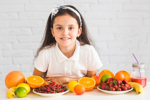 Frutas orgânicas frescas na frente da garota feliz