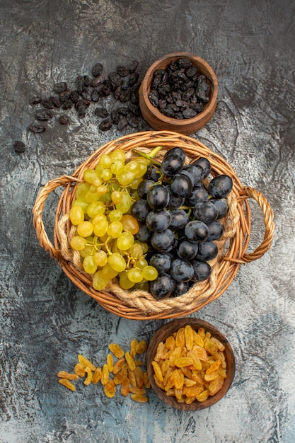 Foto grátis frutas secas as uvas apetitosas ao lado das tigelas de frutas secas