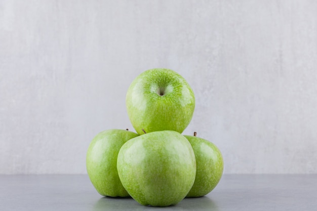 Frutas verdes frescas de maçã madura colocadas sobre uma mesa de pedra.