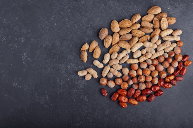 Frutos secos e feijão na superfície preta do lado direito.