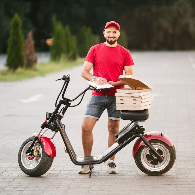 Full shot delivery guy posando ao ar livre