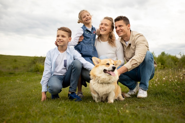 Full shot família feliz com cachorro
