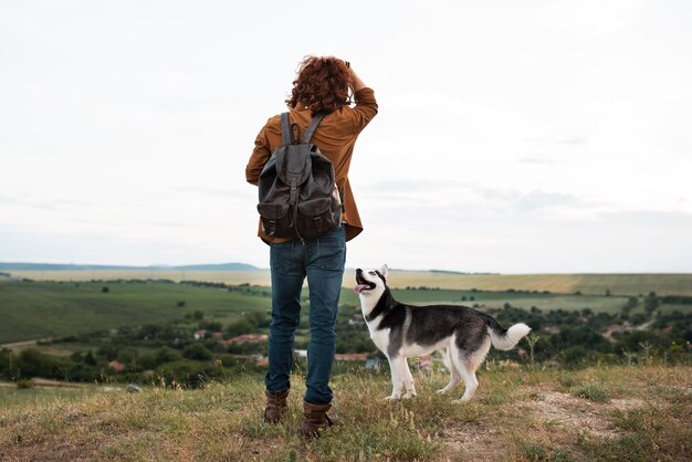 Full shot man e fofo husky por natureza