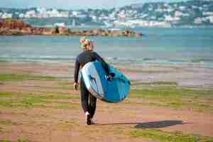 Foto grátis full shot mulher caminhando com stand up paddle