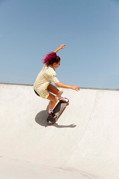 Full shot mulher com skate ao ar livre