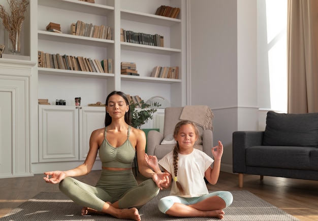 Foto grátis full shot mulher e criança meditam