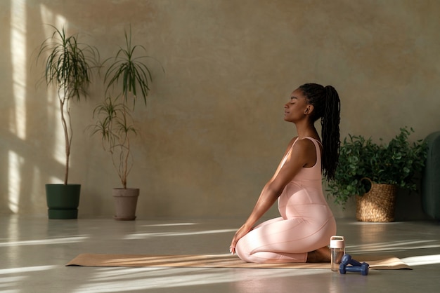 Full shot mulher grávida meditando