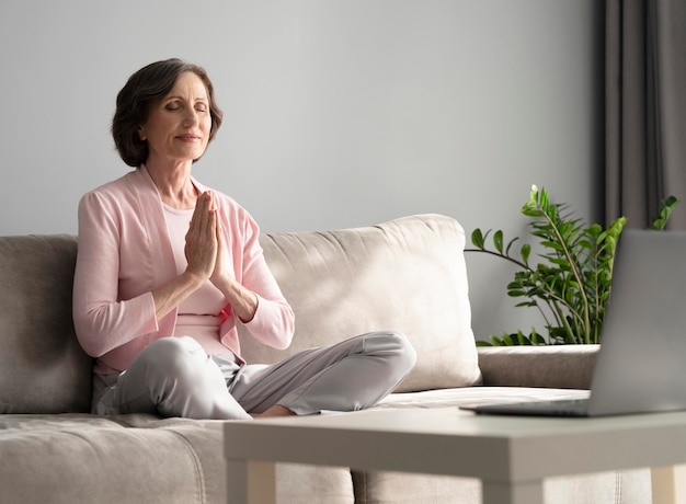 Foto grátis full shot mulher meditando dentro de casa