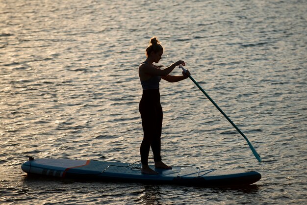 Full shot mulher paddleboarding