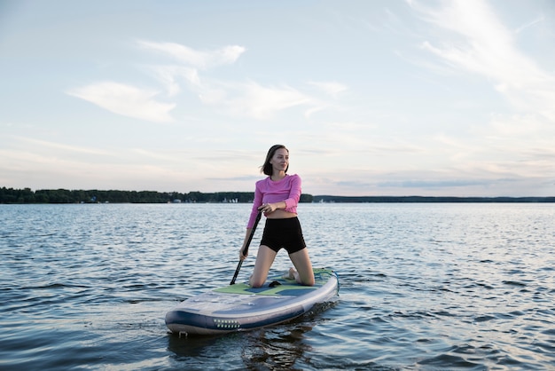 Full shot mulher sorridente de paddleboarding