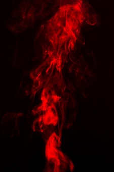 Fumaça vermelha brilhante em fundo escuro