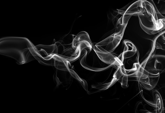 Fume o incenso branco sobre um fundo preto para design. conceito de escuridão