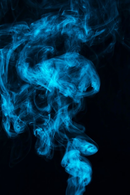Foto grátis fumo de vapor azul espalhar contra fundo preto