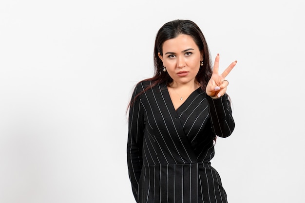 funcionária de escritório vestida de terno preto, posando em branco