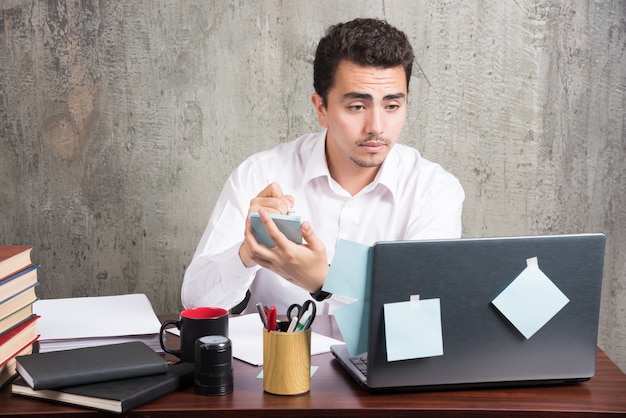 Funcionário do escritório olhando para o laptop na mesa do escritório.