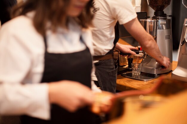 Funcionários de cafeteria trabalhando em máquinas de café