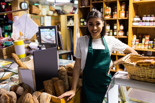 Funcionários do sexo feminino em pé no balcão de pão