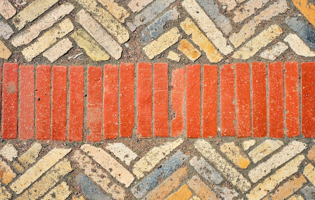 Fundo abstrato da vista superior de paralelepípedos de cerâmica de tijolos antigos Caminhos antigos dispostos em padrões geométricos em lascas de granito A ideia de papel de parede para uma mesa ou um protetor de tela para publicidade