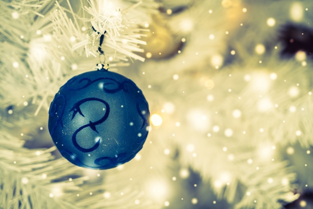 Fundo brilhante com uma esfera azul do Natal