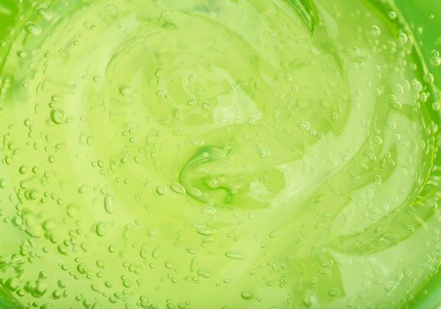 Fundo de gel cosmético gel transparente verde com textura e bolhas close-up foto de alta qualidade