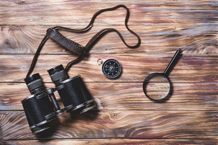 Foto grátis fundo de madeira com binocular, compasso e lupa