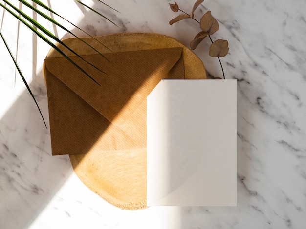 Fundo de mármore com uma placa de madeira com um envelope marrom e um espaço em branco branco