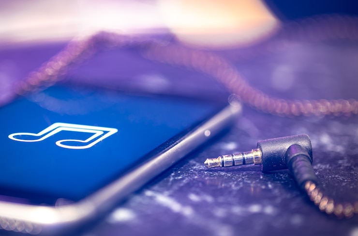Foto grátis fundo de música com um ícone de escuta de música no telefone e fones de ouvido.