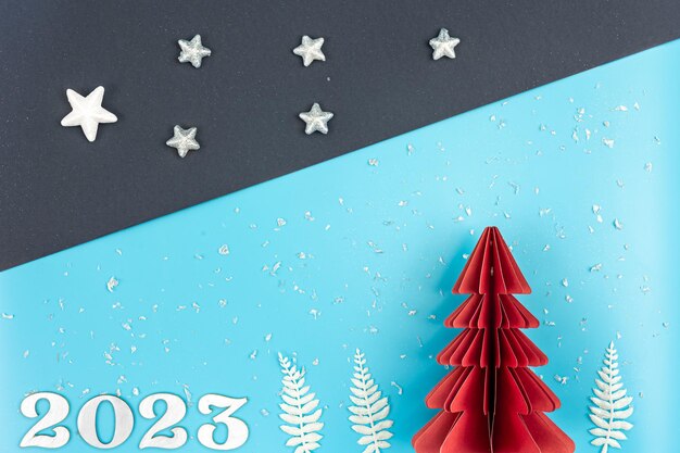 Fundo de natal com árvore de papel origami e número 2023 flat lay