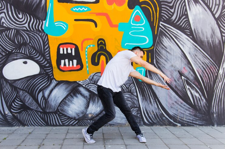 Foto grátis funil de quadril realizando dança na frente da parede de graffiti
