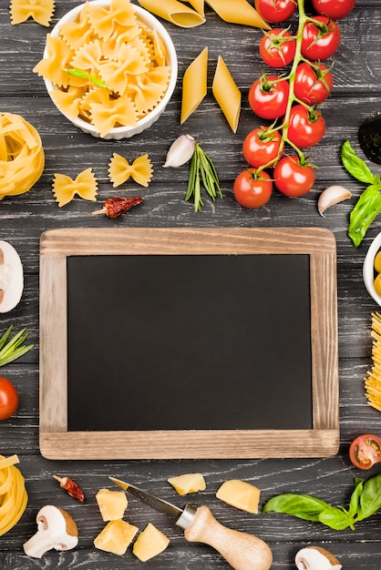 Foto grátis fusilli com ingredientes de legumes e lousa