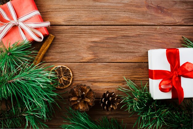 Galho de Natal e caixas de presentes na mesa de madeira