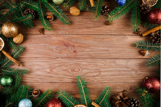 Galhos de Natal e bolas de enfeite na mesa de madeira