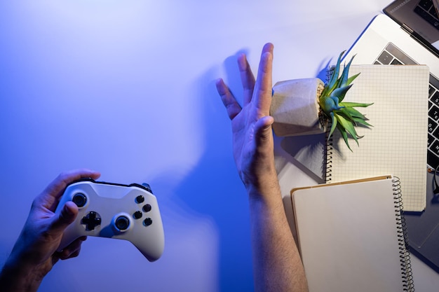 Foto grátis gamepad em mãos masculinas no local de trabalho, tempo de descanso sem visão superior do trabalho