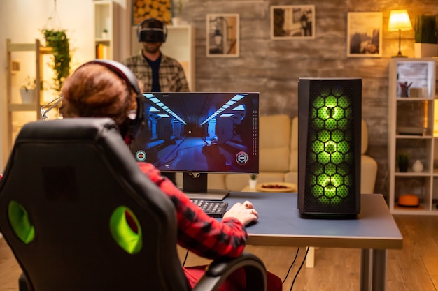 Foto grátis gamer profissional de vídeo jogando um jogo de tiro online tarde da noite na sala de estar