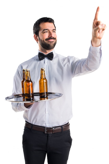 Foto grátis garçom com garrafas de cerveja na bandeja tocando na tela transparente