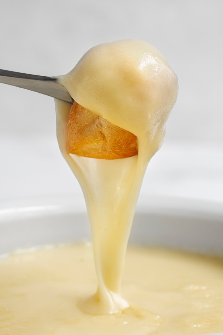 Foto grátis garfo com cogumelos mergulhado em queijo derretido