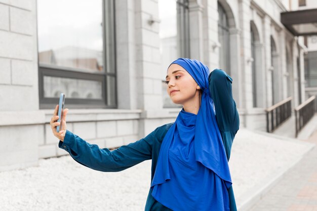 Garota adolescente em tiro médio tirando uma selfie