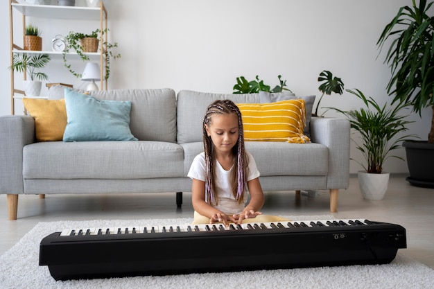 Garota adorável tocando piano em casa