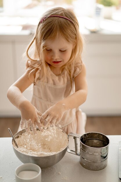 garota ajuda a mãe na cozinha a cozinhar bolos de Páscoa. Família feliz se preparando para a Páscoa