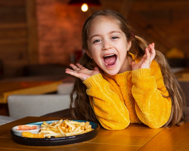 Foto grátis garota animada com tiro médio e comida