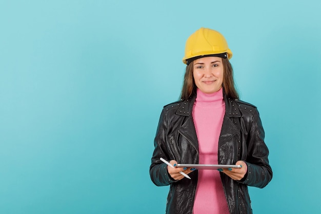 Garota arquiteta está sorrindo segurando computador tablet em fundo azul