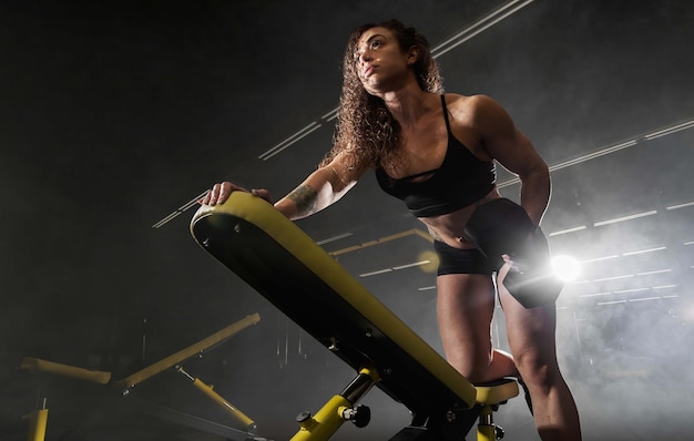 Foto grátis garota atlética faz exercícios usando equipamentos esportivos em uma academia