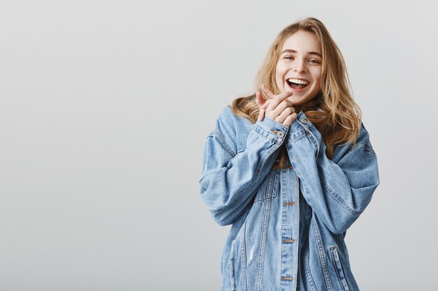 Garota atraente feliz batendo palmas e sorrindo deliciada, receba surpresa incrível