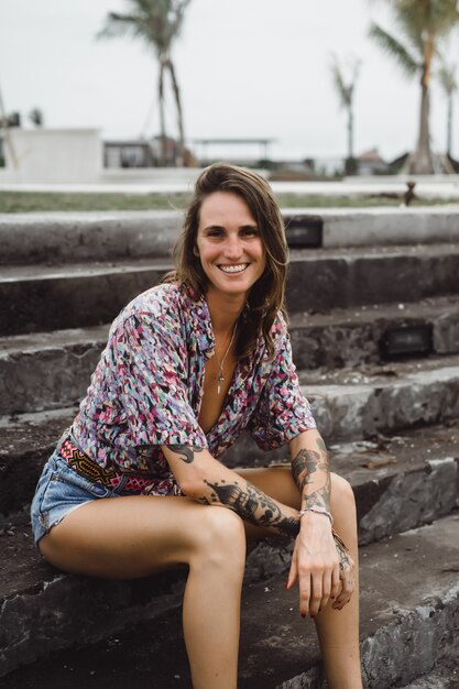 garota bonita em shorts jeans com pernas longas, vestindo uma camisa colorida