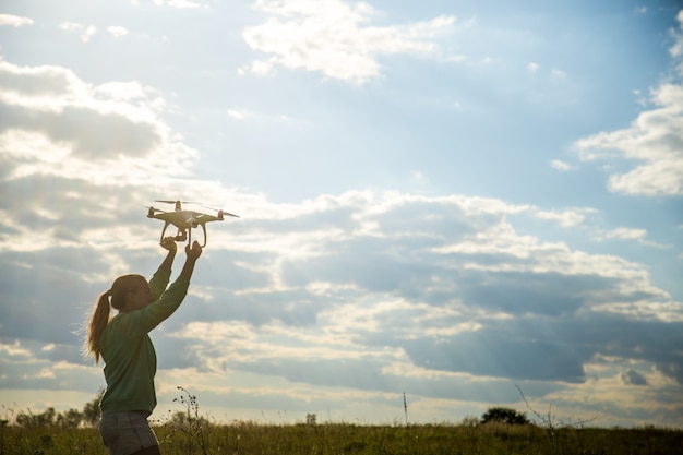 Foto grátis garota bonita em um campo lança o drone no céu