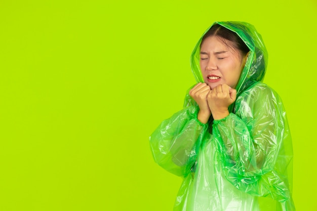 garota bonita feliz, vestindo roupas verdes, guarda-chuva e casaco, dia chuvoso.